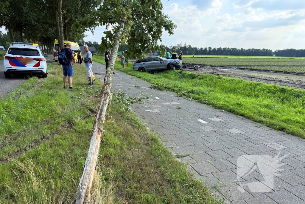 Auto raakt boom en belandt in sloot