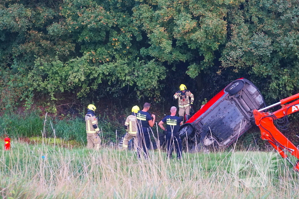 Auto rijdt van dijk af en slaat voorover