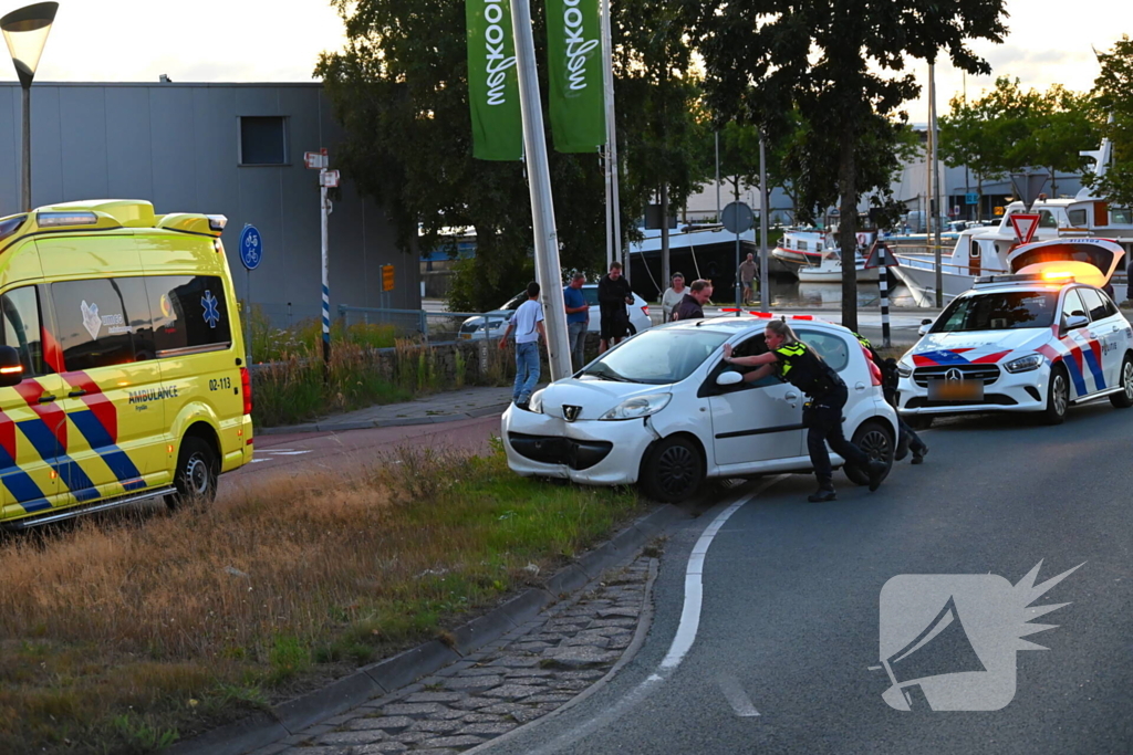 Auto crasht op rotonde en raakt paal