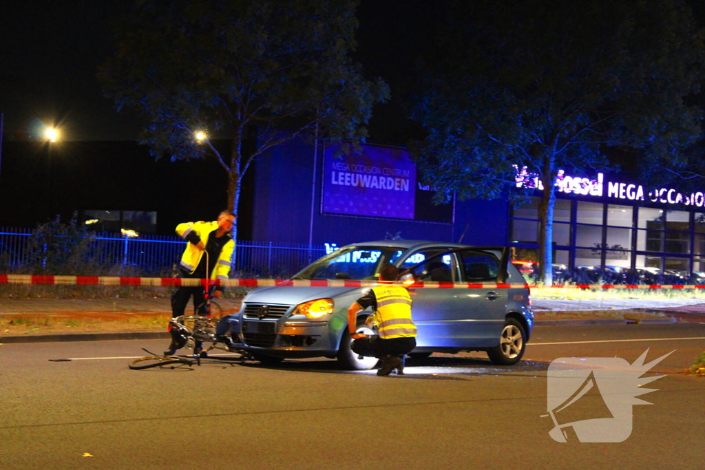 Fiets belandt onder auto bumper