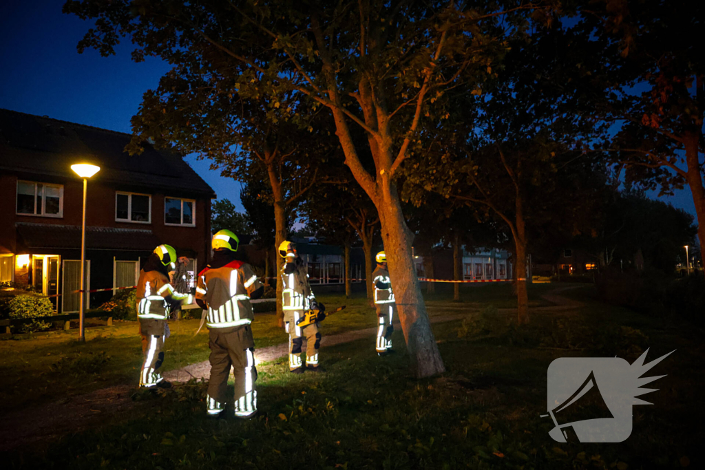 Brandweer zaagt takken van schuinstaande boom af