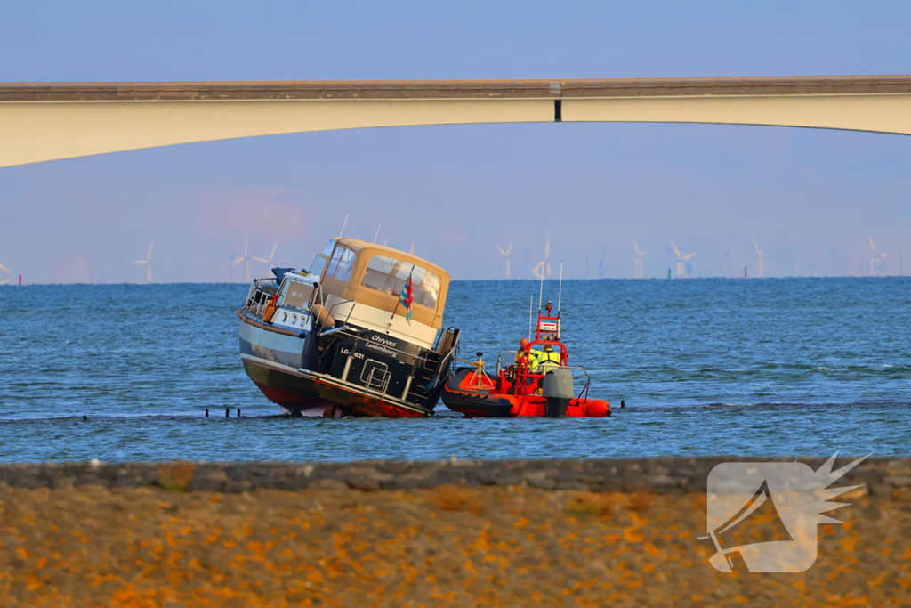 Boot loopt vast op dam, bergingsbedrijf schiet te hulp