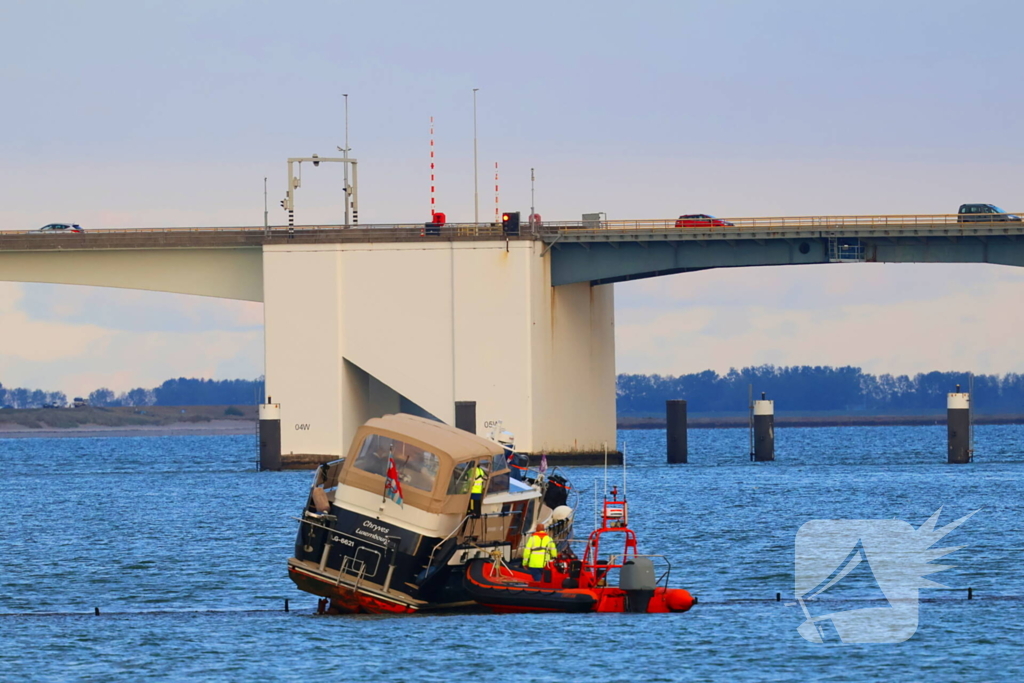 Boot loopt vast op dam, bergingsbedrijf schiet te hulp