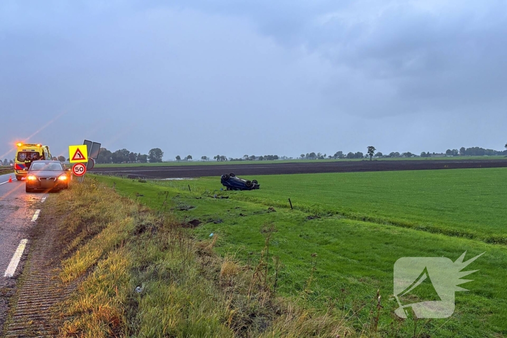 Auto belandt op dak in weiland