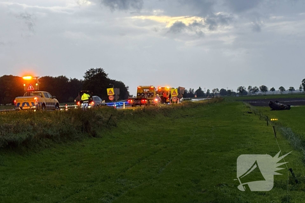 Auto belandt op dak in weiland