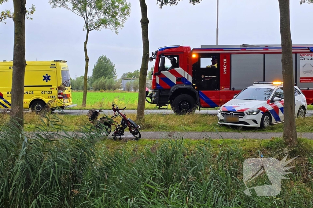 persoon op driewielfiets in water beland