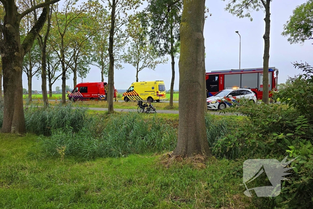 persoon op driewielfiets in water beland