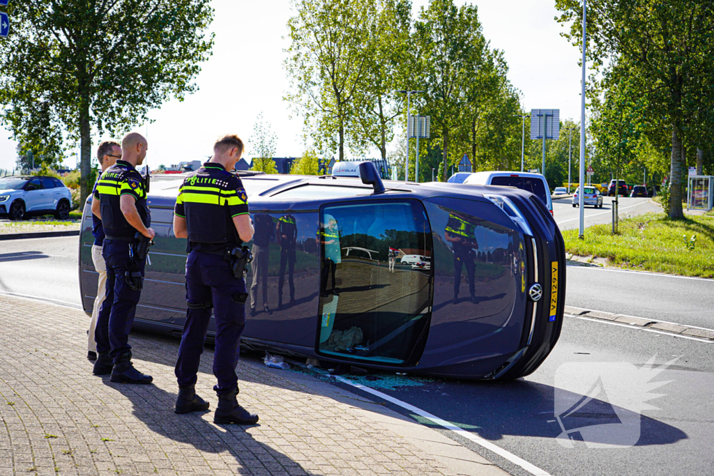 Bestelbus op zijn kant na botsing
