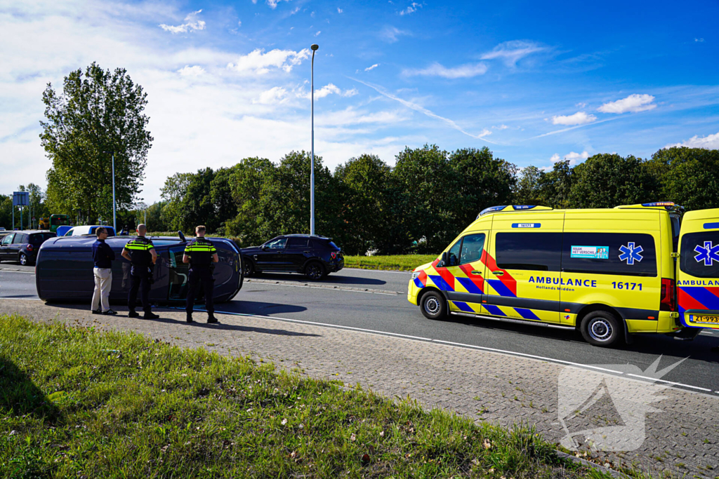 Bestelbus op zijn kant na botsing
