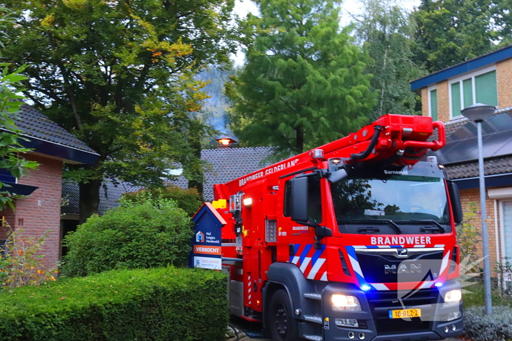 Vlammen slaan uit schoorsteen