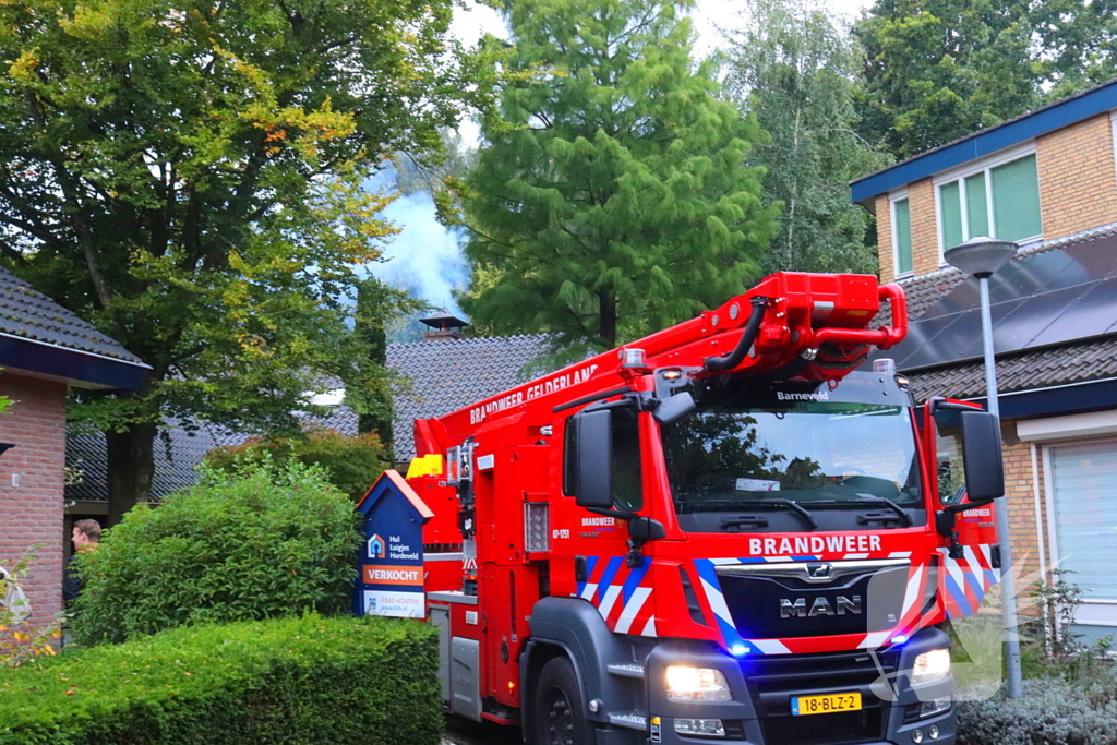 Vlammen slaan uit schoorsteen