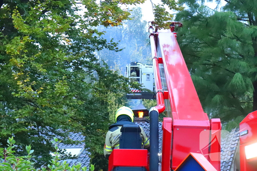 Vlammen slaan uit schoorsteen