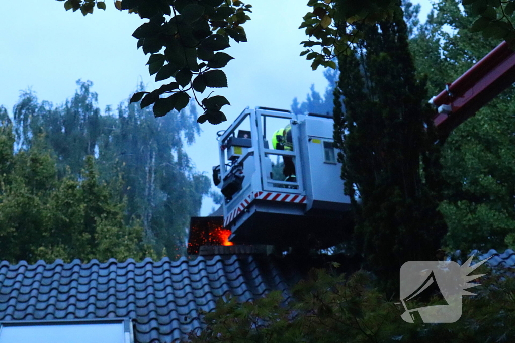 Vlammen slaan uit schoorsteen