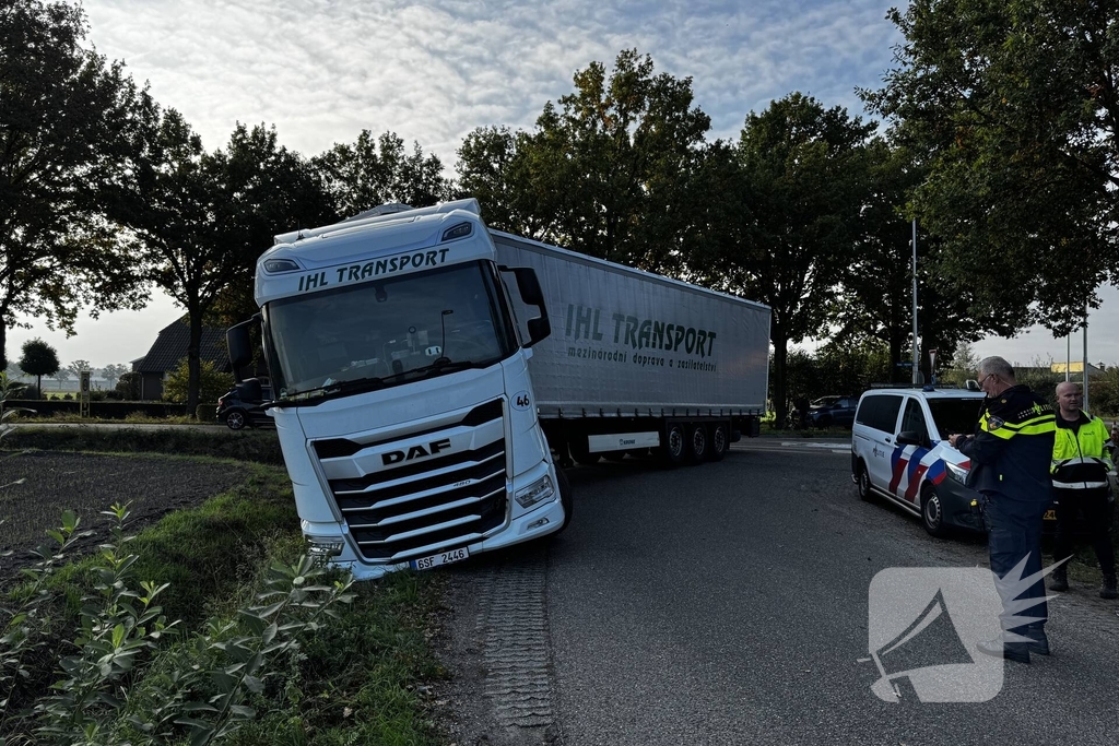 Vrachtwagencombinatie vast in berm