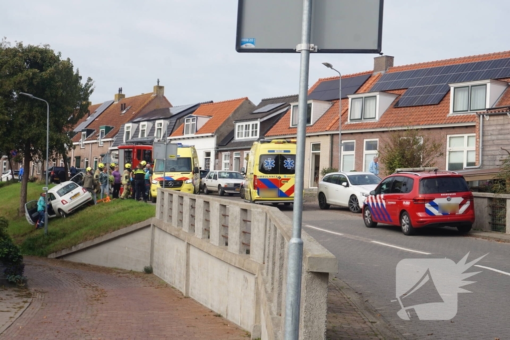 Auto van dijk gereden, bestuurder met spoed naar ziekenhuis
