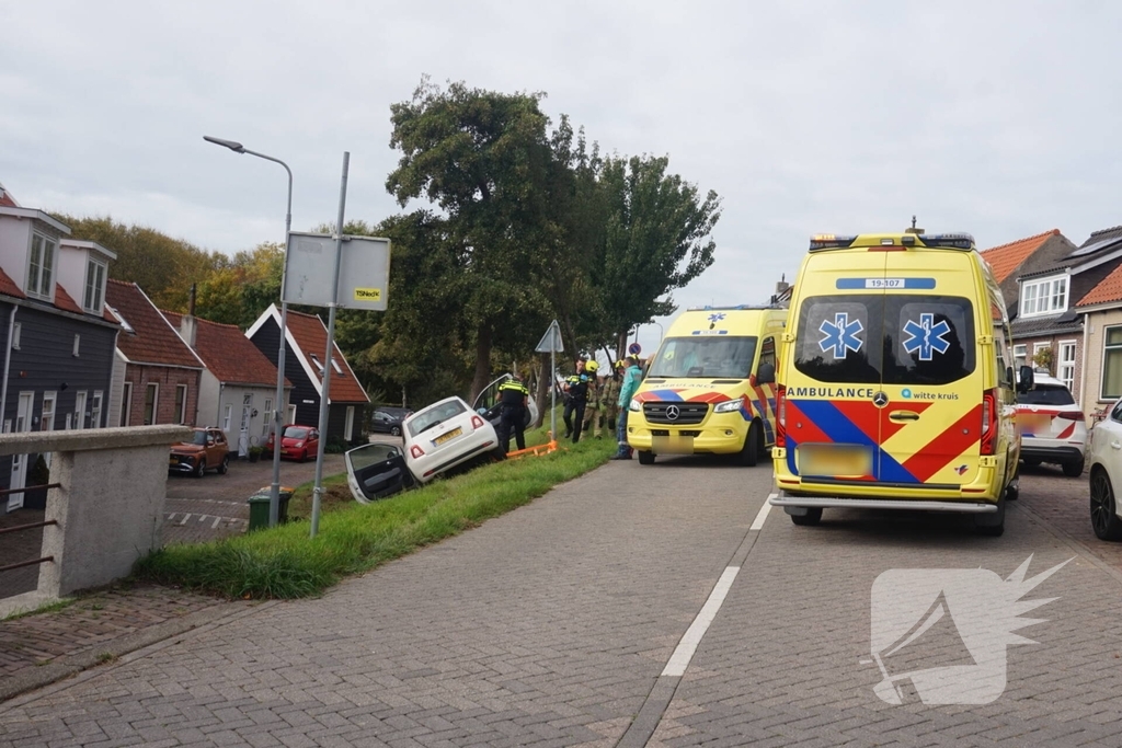 Auto van dijk gereden, bestuurder met spoed naar ziekenhuis