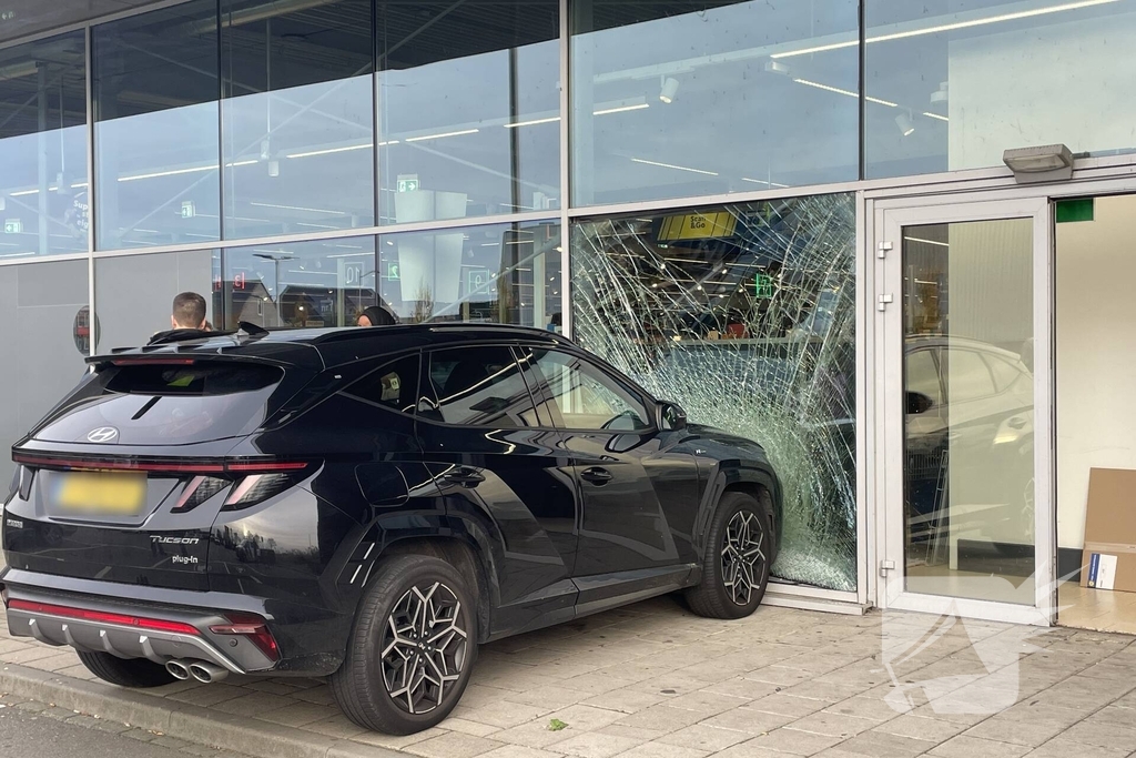 Automobilist ramt gevel supermarkt