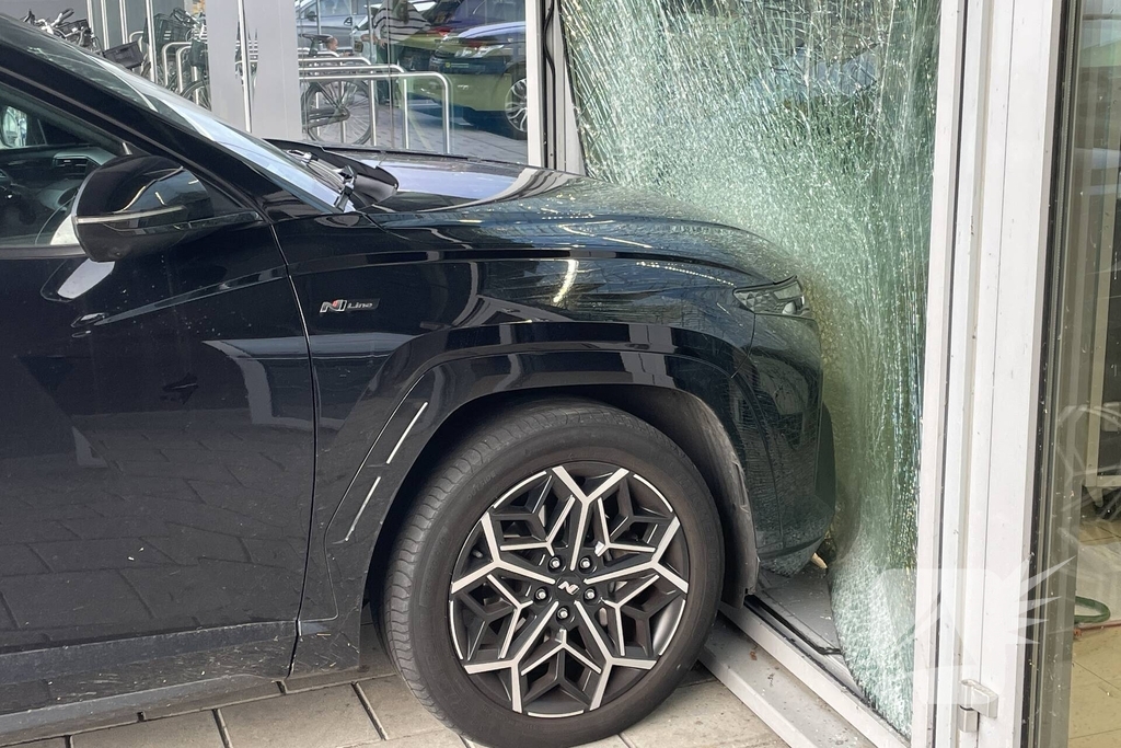 Automobilist ramt gevel supermarkt