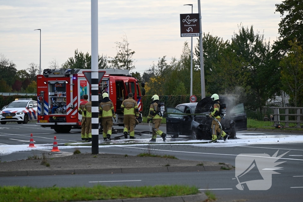 Brandweer blust brandende auto