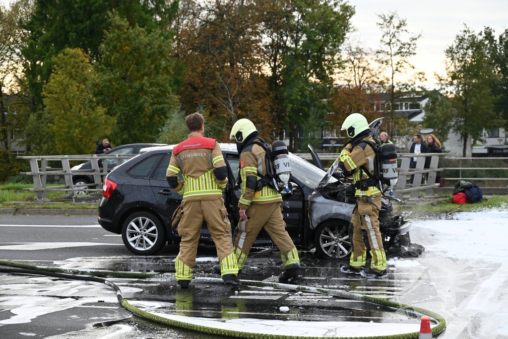 Brandweer blust brandende auto
