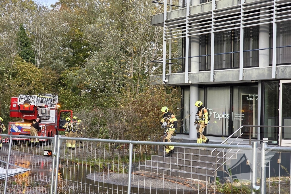 Kantoorpand brandt, rook uit bovenverdieping