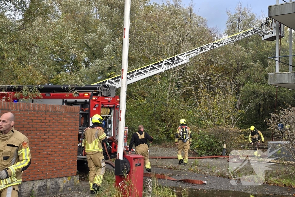 Kantoorpand brandt, rook uit bovenverdieping