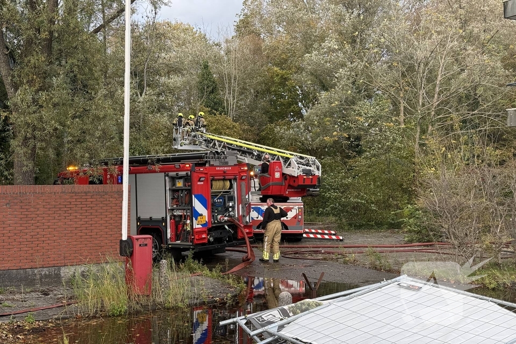 Kantoorpand brandt, rook uit bovenverdieping