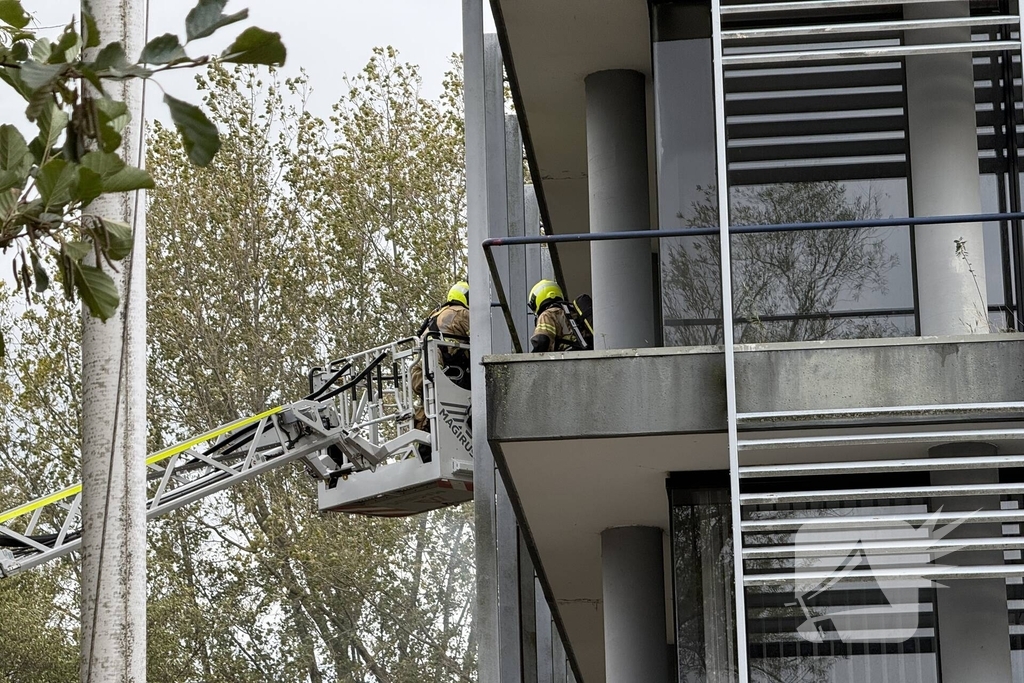 Kantoorpand brandt, rook uit bovenverdieping