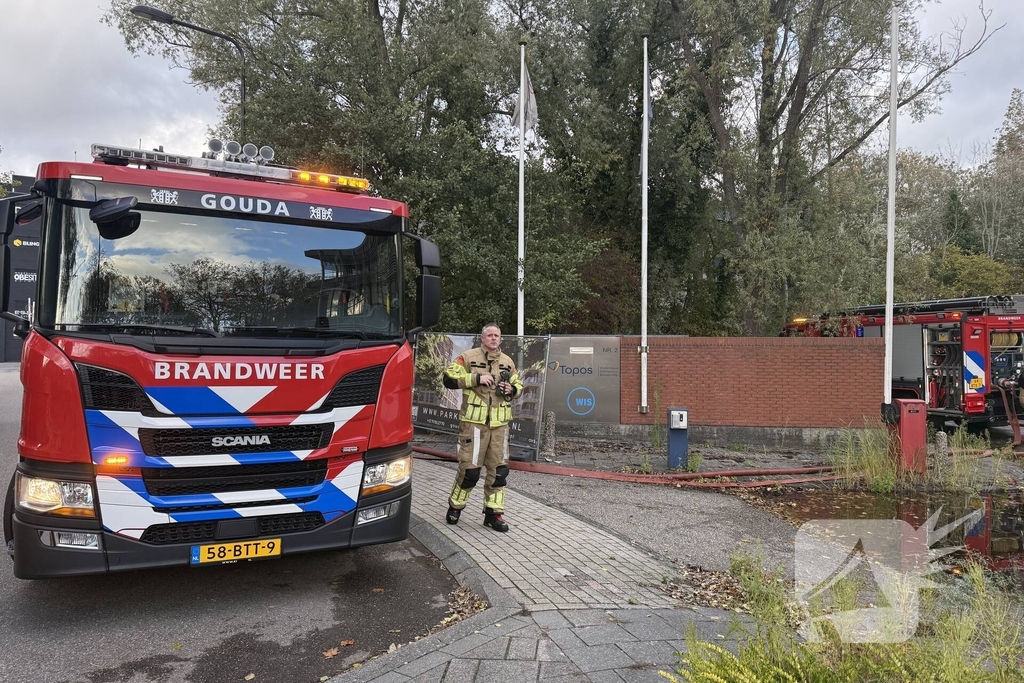 Kantoorpand brandt, rook uit bovenverdieping