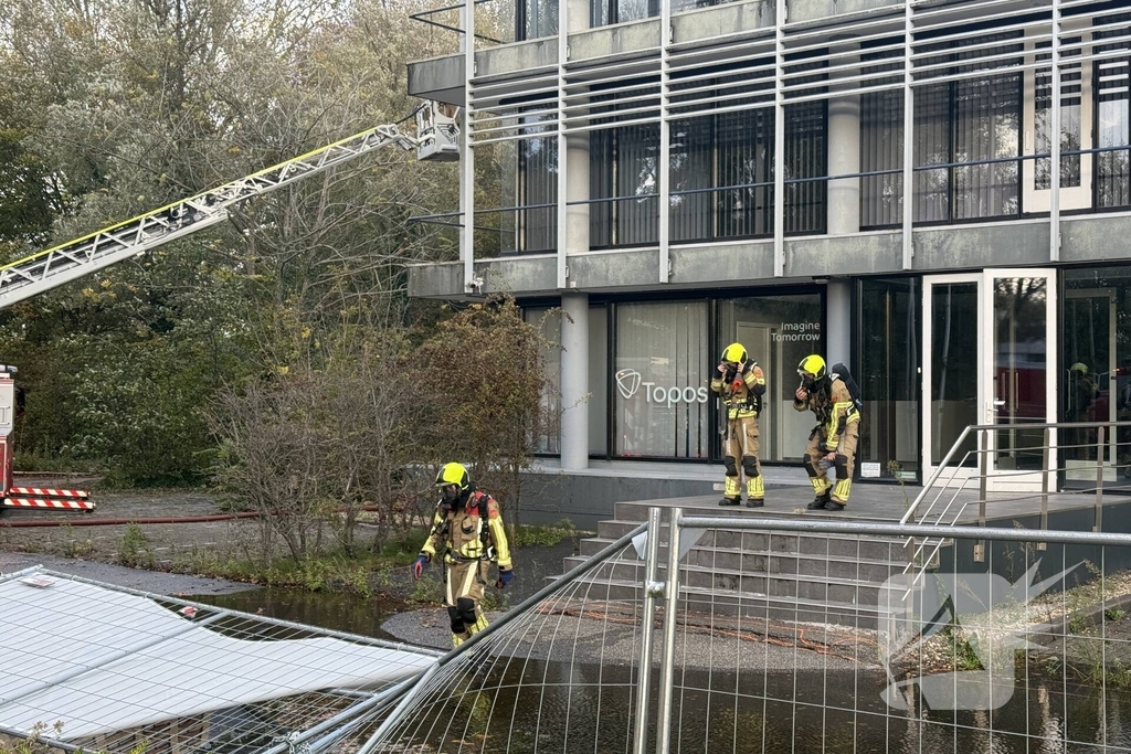 Kantoorpand brandt, rook uit bovenverdieping