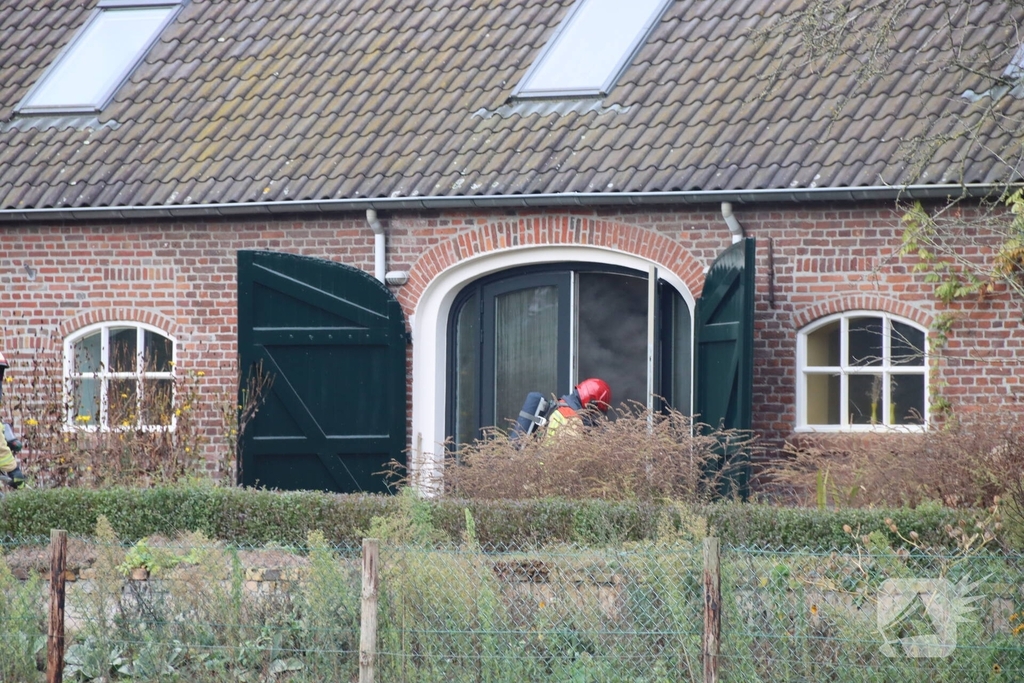 Rookwolken stijgen boven woning uit