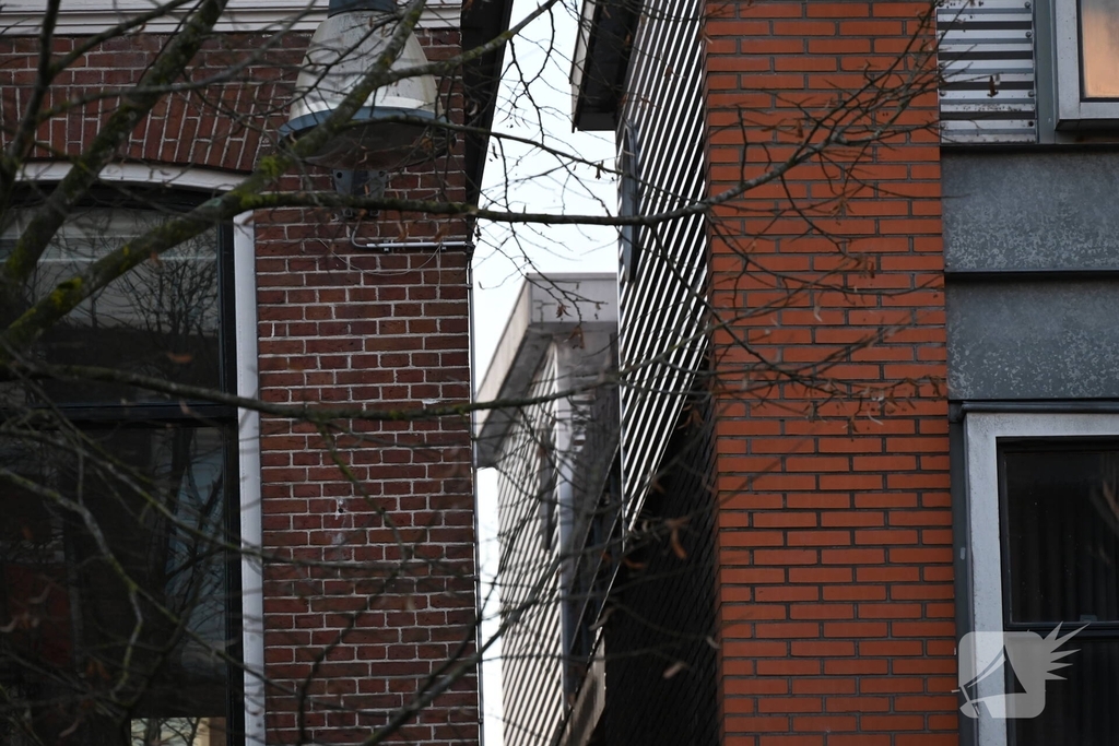 Rook zichtbaar boven pand