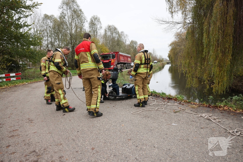 Man met scootmobiel te water