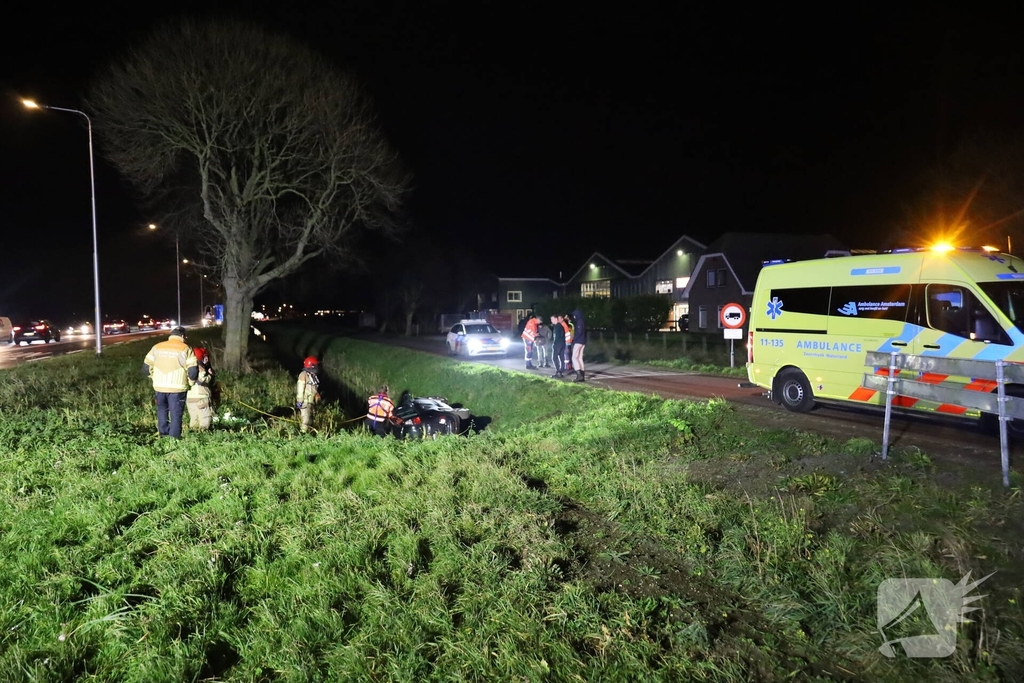 Auto belandt op zijkant in sloot
