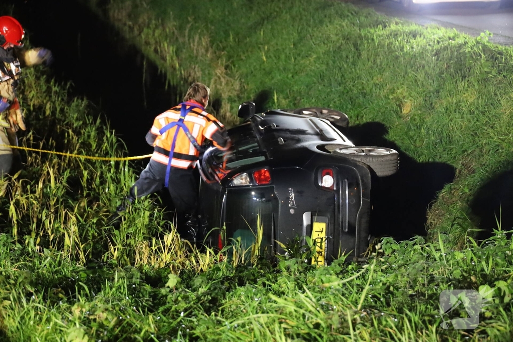 Auto belandt op zijkant in sloot