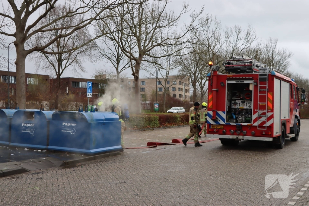 Brandweer dooft brand in papiercontainer