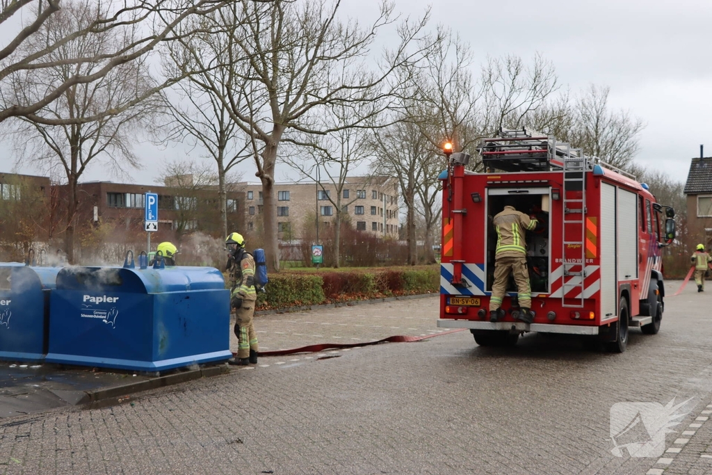Brandweer dooft brand in papiercontainer