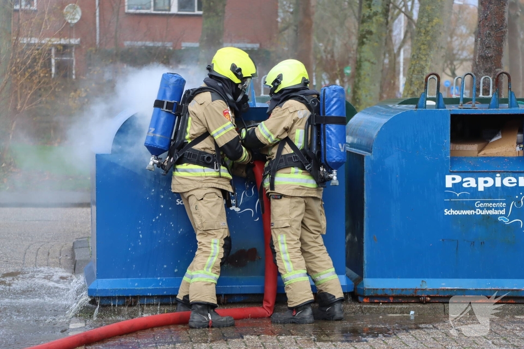 Brandweer dooft brand in papiercontainer