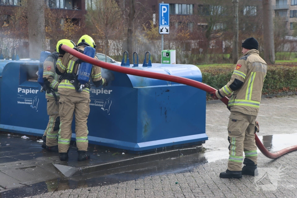 Brandweer dooft brand in papiercontainer