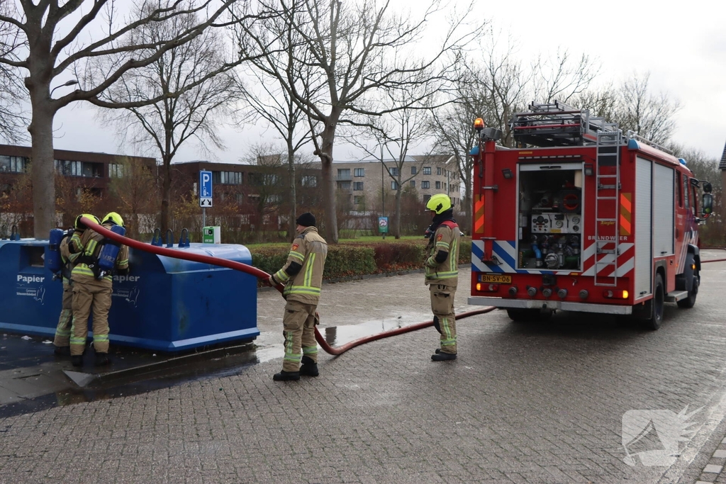 Brandweer dooft brand in papiercontainer
