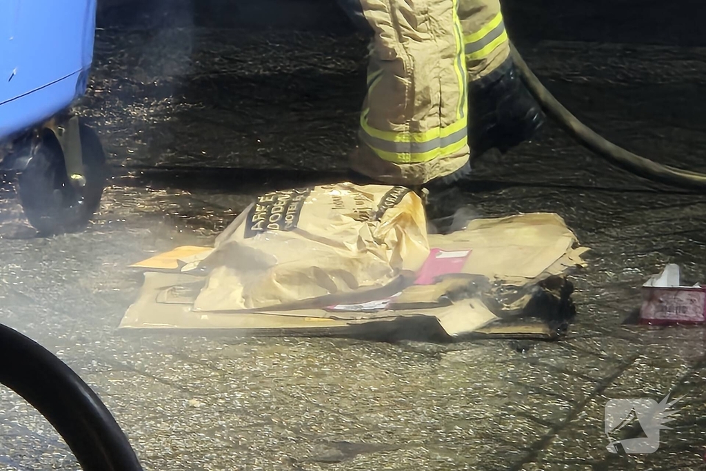 Brandweer dooft brand in papiercontainer