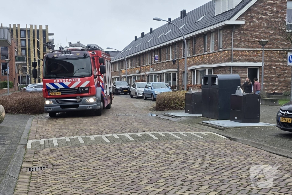 Container vat vlam door vuurwerk, omstanders doen bluspoging