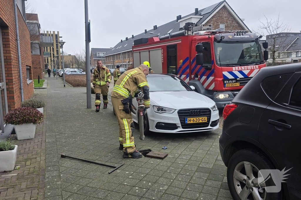 Container vat vlam door vuurwerk, omstanders doen bluspoging