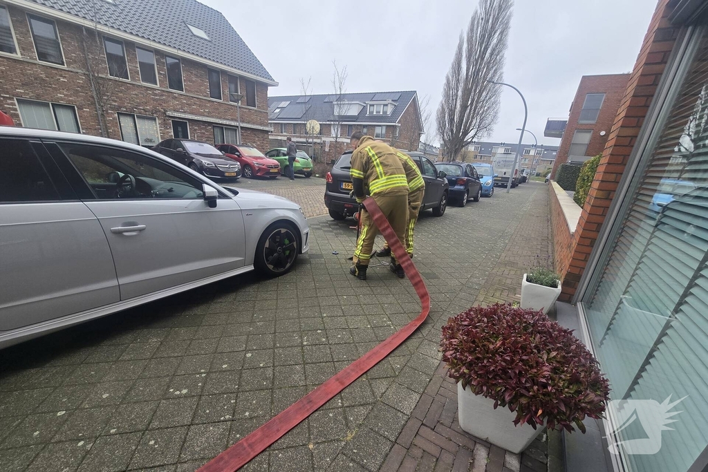 Container vat vlam door vuurwerk, omstanders doen bluspoging