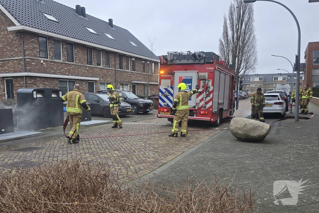 Container vat vlam door vuurwerk, omstanders doen bluspoging