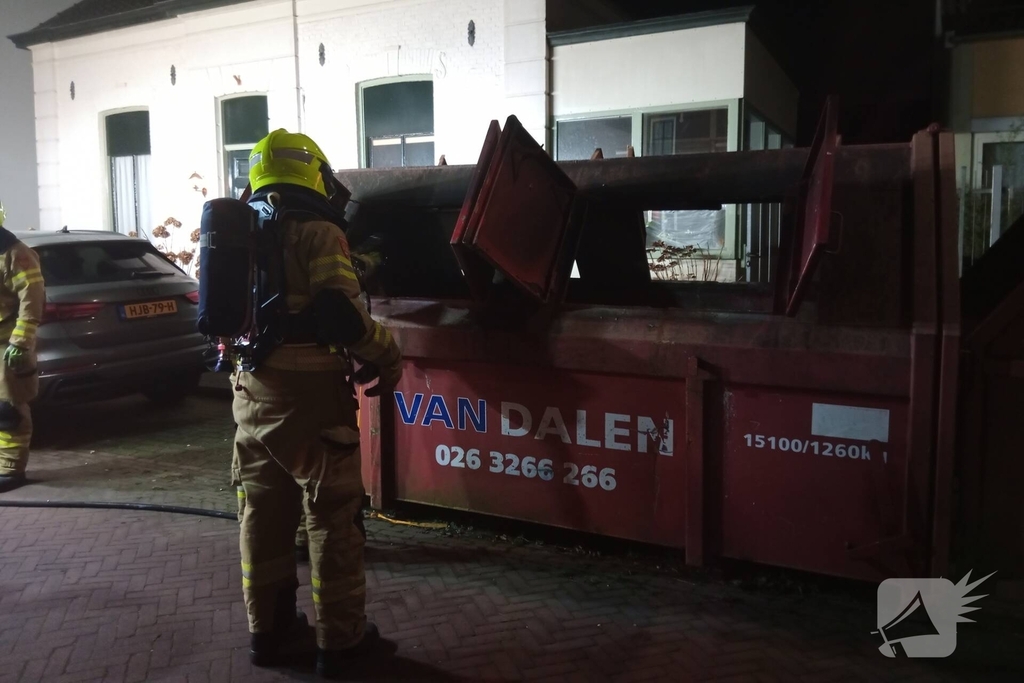 Omwoners starten met blussing van containerbrand