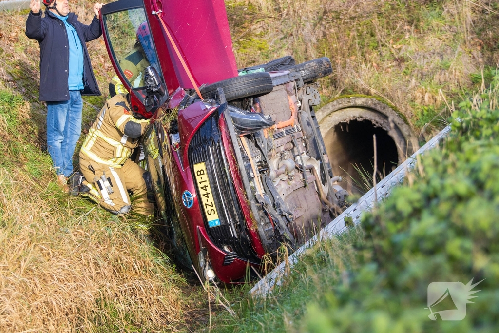 Auto op zijkant in greppel na ongeval