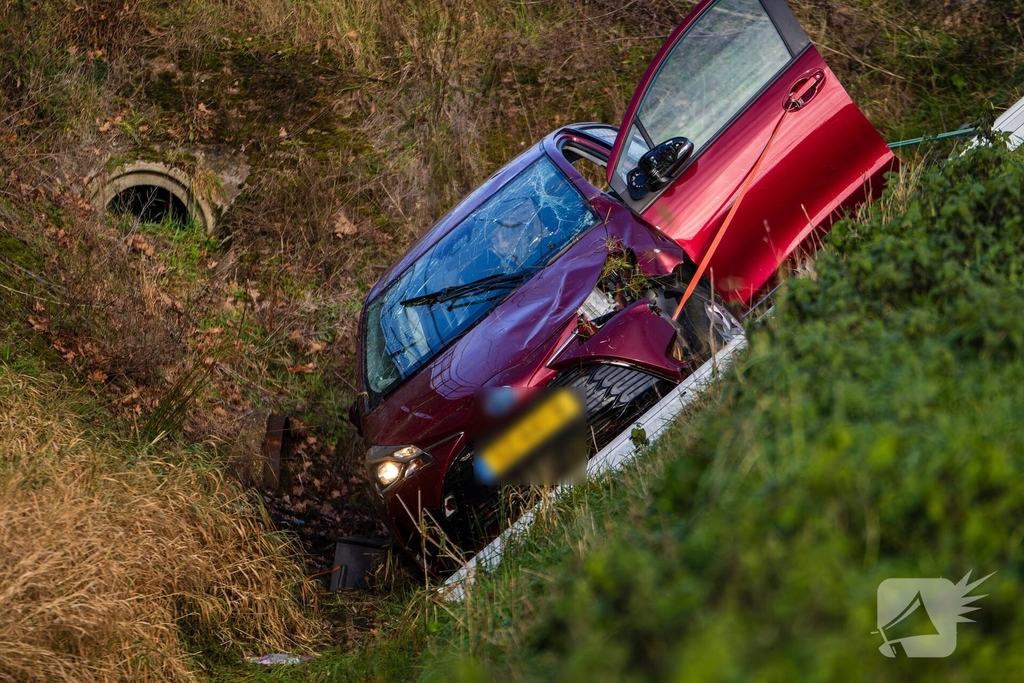 Auto op zijkant in greppel na ongeval