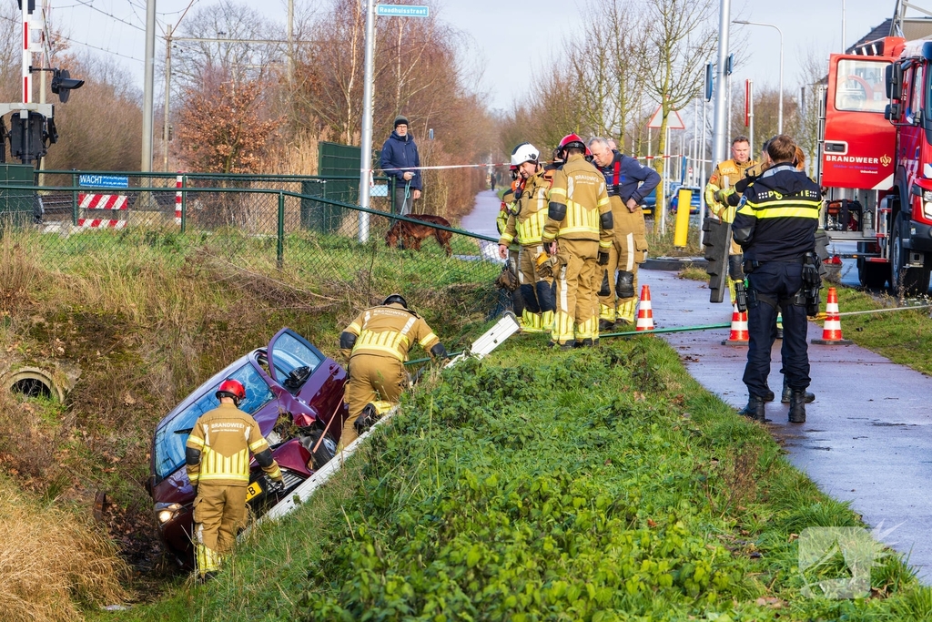 Auto op zijkant in greppel na ongeval
