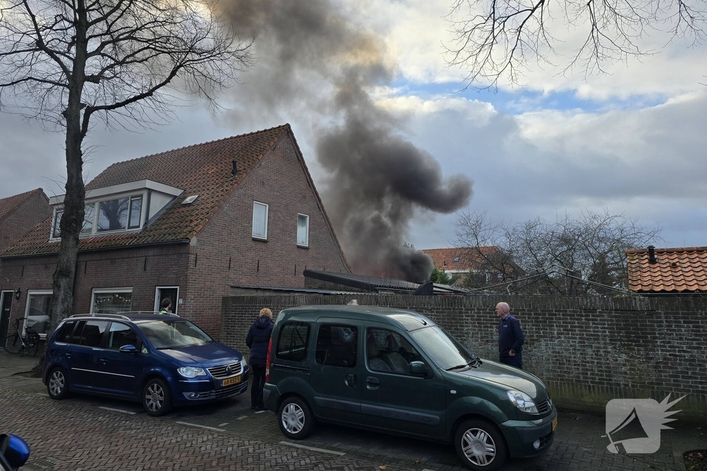Vlammen, explosies en zwarte rook bij brand achter woning